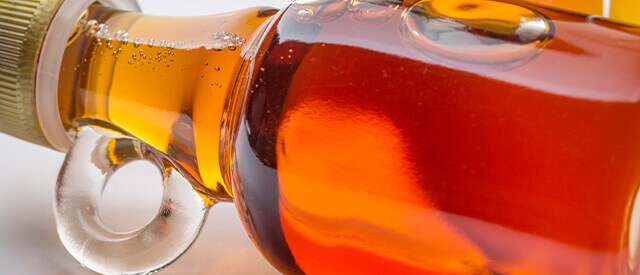 close up of maple syrup in glass bottle