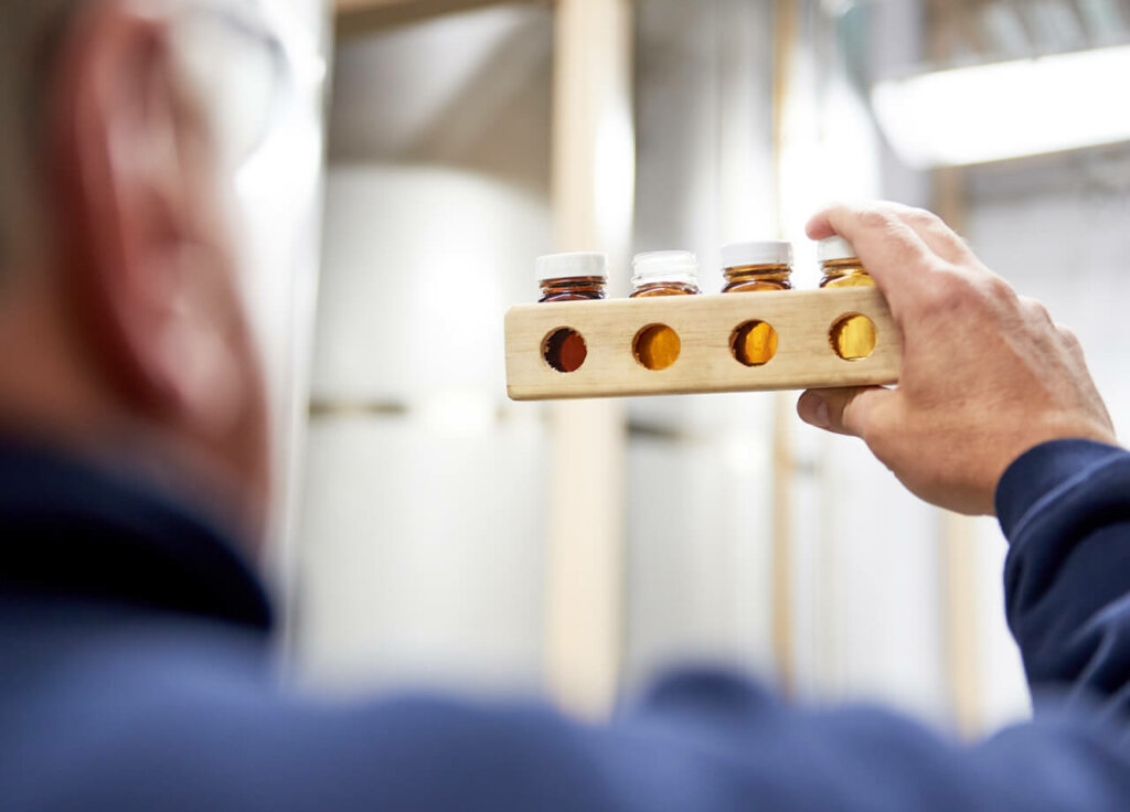 Man holding syrup in test tubes