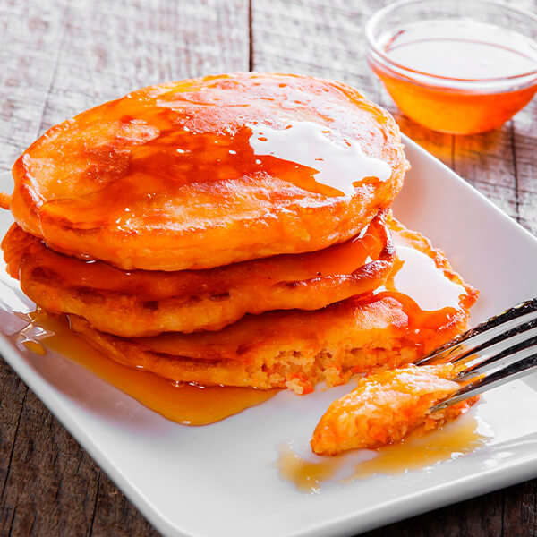 stack of fluffy pancakes with maple syrup