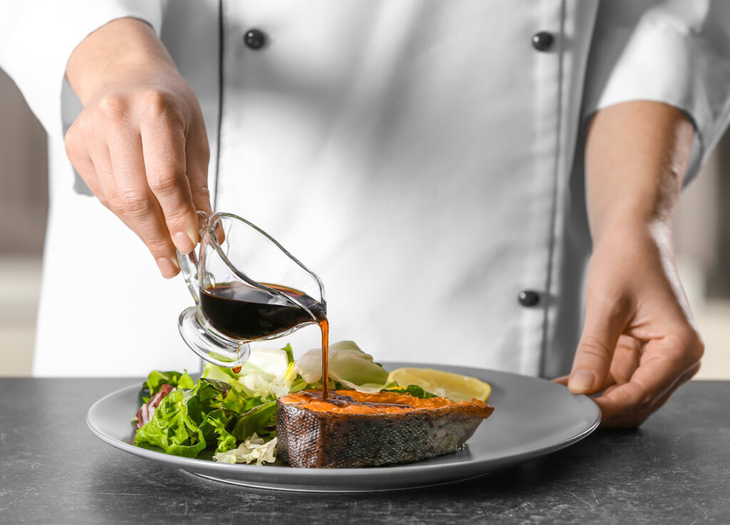 chef pouring maple syrup over sweet potatoes